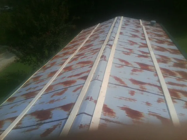 Rusted metal roof panels with new wood purlins before replacement — Storm Damage Roof Repair in Euless by Roofing Brothers