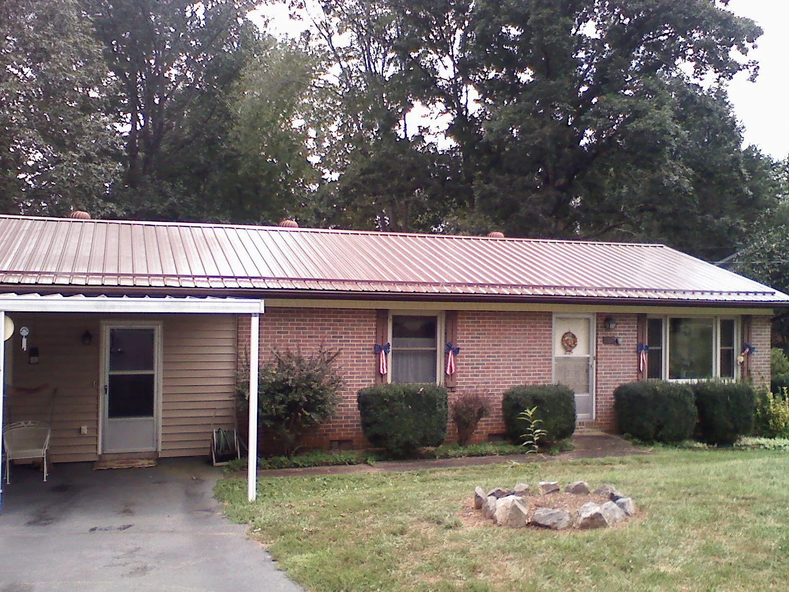 Bronze metal roof and carport on a brick ranch home — Roof Repair work by our crew in Euless